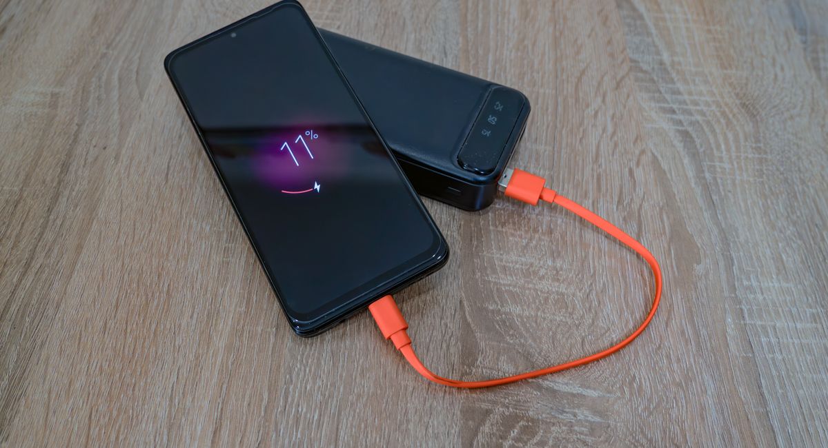 Portable power bank charging a smartphone during motorcycle travel