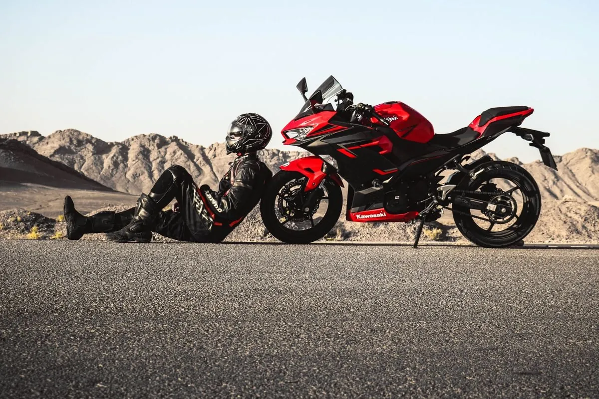 Damaged touring motorcycle parked on the shoulder of a highway after being rear-ended