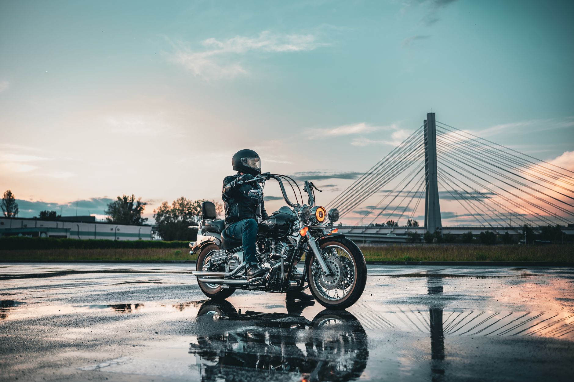 Motorcycle riding in heavy rain at sunset