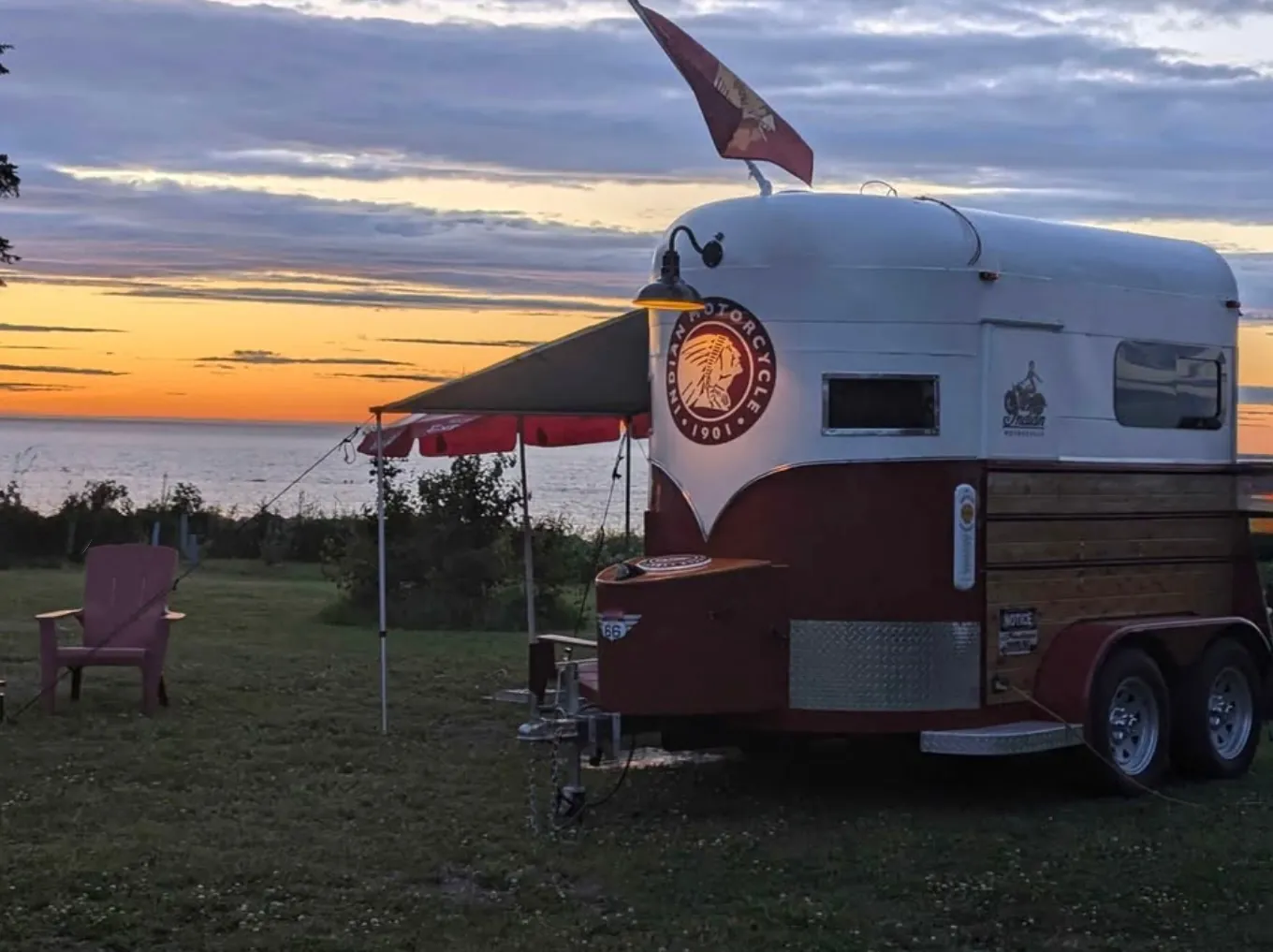Custom Indian Motorcycle trailer at sunset with awning out and Indian flag flying