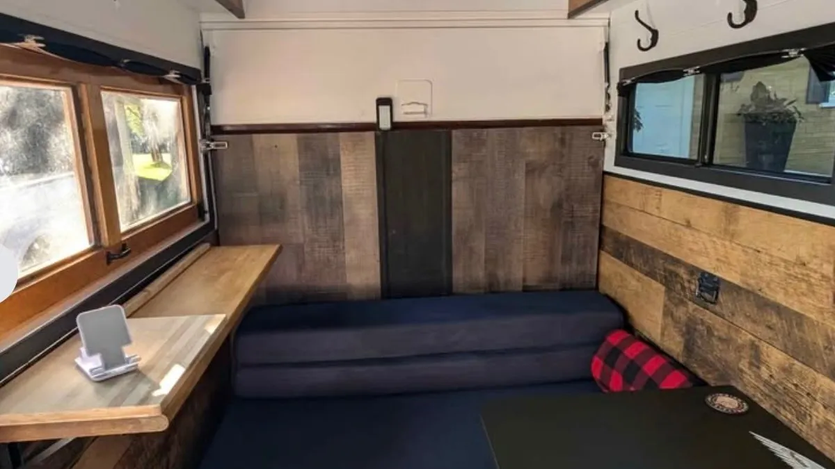 Interior of the custom Indian Motorcycle trailer with wood panelling and fold-out seating