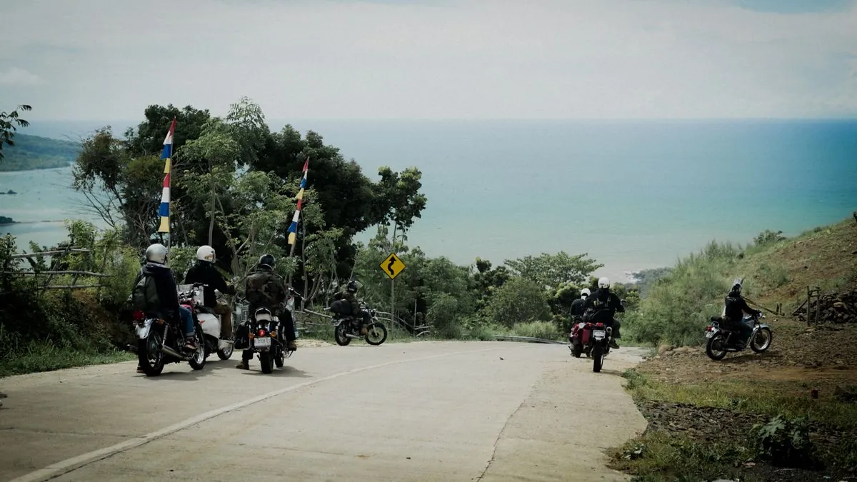 Group of motorcyclists riding along a scenic coastal road